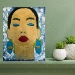 Der Hintergrund ist olivegrün. Ein Bild steht auf einer Ablage. Es hat Pflanzen. Das Bild ist mit Acryltechnik gemalt. Es ist der Kopf einer Frau, die die Auge geschlossen hat und meditiert.