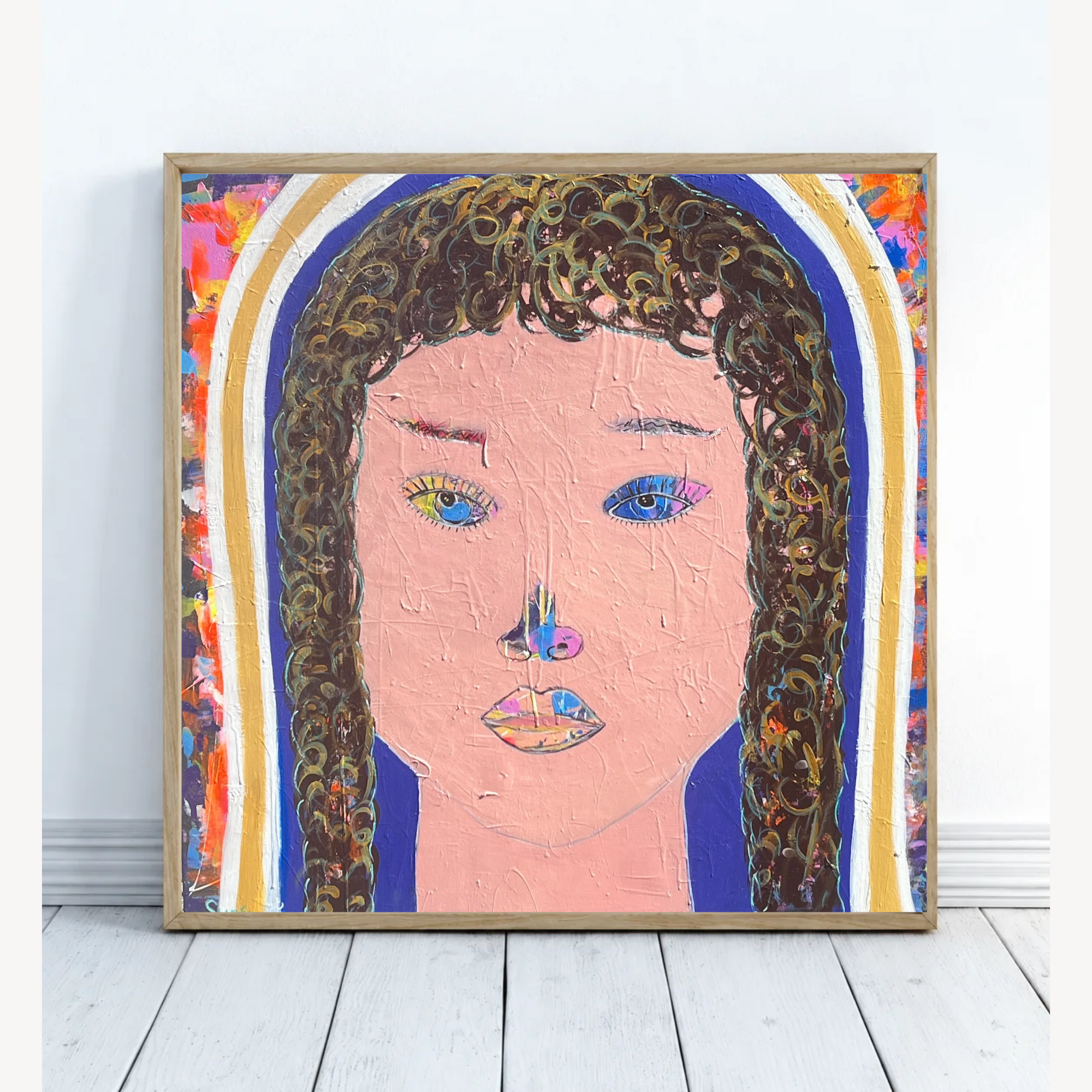 Quadratisches farbenfrohes Porträtgemälde einer Frau mit dunklen Locken und unterschiedlich farbigen Augen, in einem schmalen Holzrahmen an eine weiße Wand gelehnt.